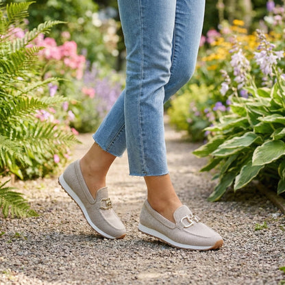 Beige mesh slip-ons with gold buckle worn with cropped jeans on a garden gravel path 11