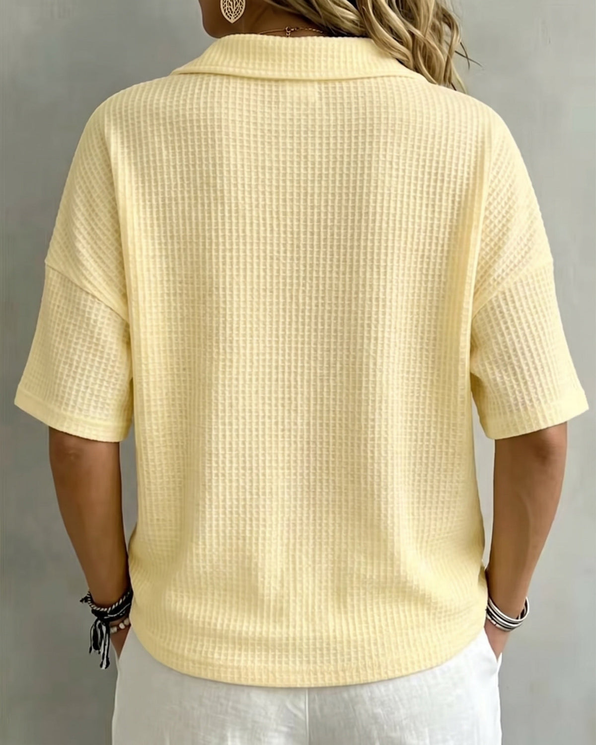 Back view of the pale yellow waffle knit top, showing the collar, drop shoulders and short sleeves 3