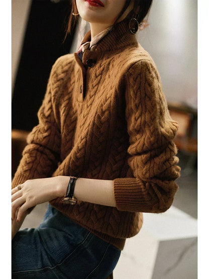 Side view of a seated model in the brown cable-knit sweater, with ribbed cuffs, scarf and a black-strapped watch. 5