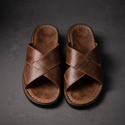 Top-down view of a pair of brown crossed-strap sandals side by side, showing the woven strap crossing and stitched footbeds. 4