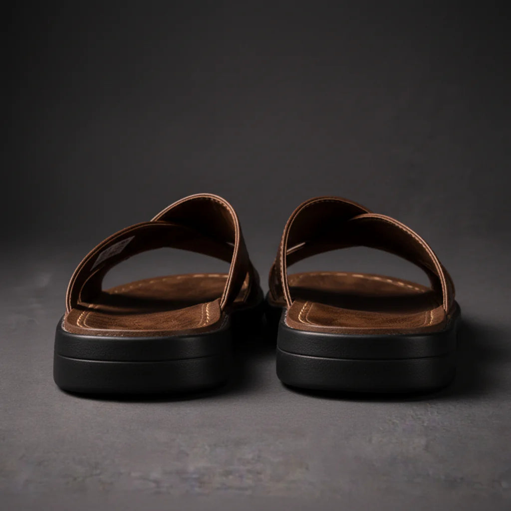 Rear view of a pair of brown sandals showing the thick black soles, open heels and stitched footbeds. 5