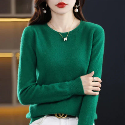 Model wearing the jumper in emerald green with white trousers, arms crossed to show the cuff 6
