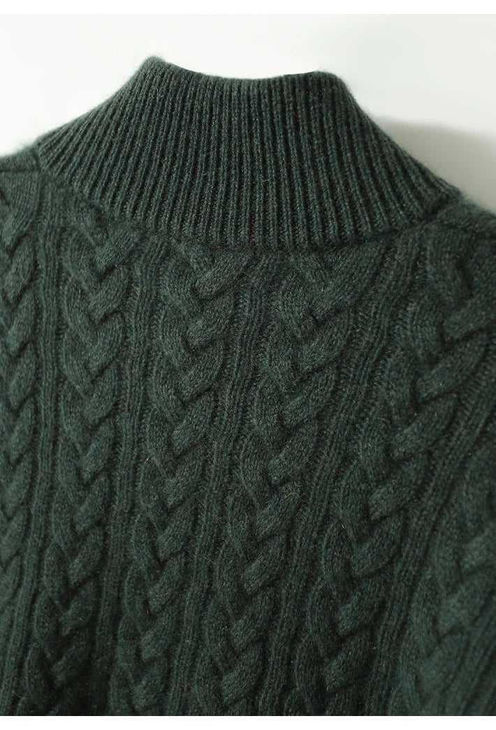 Close-up of the dark green cable-knit texture and ribbed stand collar on the back of the cashmere sweater. 21