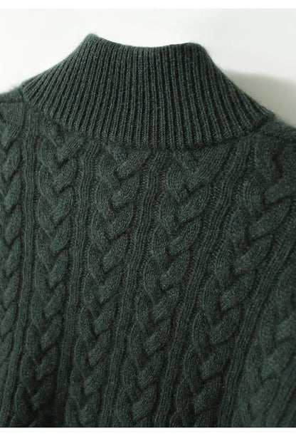 Close-up of the dark green cable-knit texture and ribbed stand collar on the back of the cashmere sweater. 21