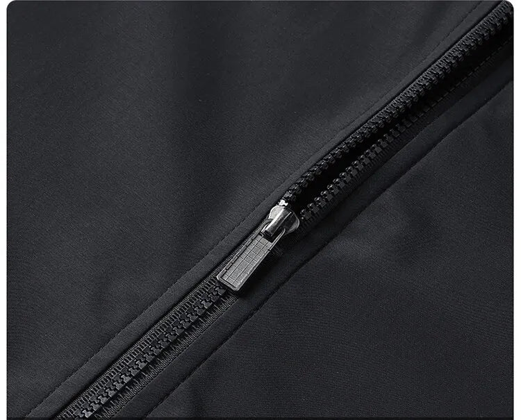 Macro view of the black jacket's chunky zip and metal pull running diagonally across the smooth fabric. 6