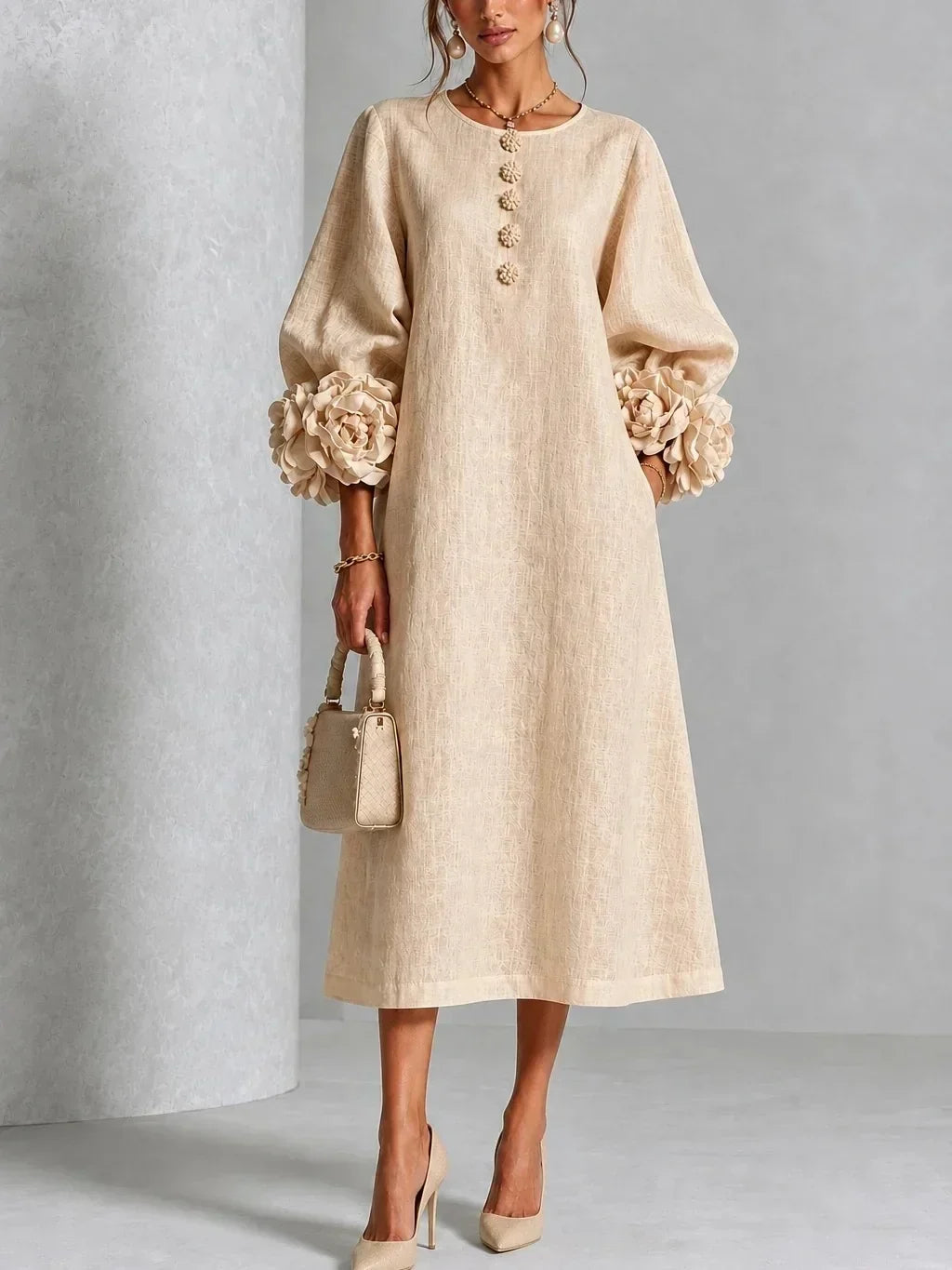 Model wears the beige version with textured fabric, flower-trimmed cuffs and flower buttons, styled with matching heels and a small woven handbag. 3