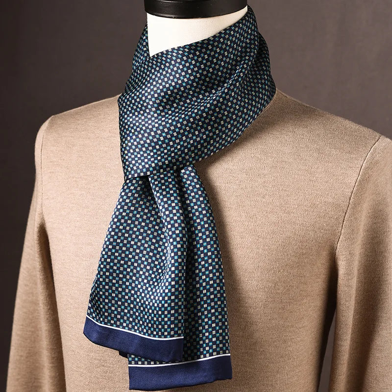 Navy silk scarf with a small blue, teal and white square check print and a thin white-lined border, worn on a mannequin. 24