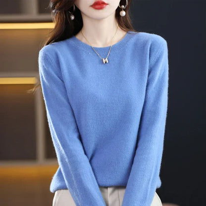 Model wearing the round-neck jumper in bright blue with cream trousers and pearl drop earrings 22