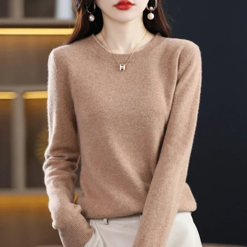 Model wearing the jumper in warm camel, one hand in a pocket of cream trousers 15