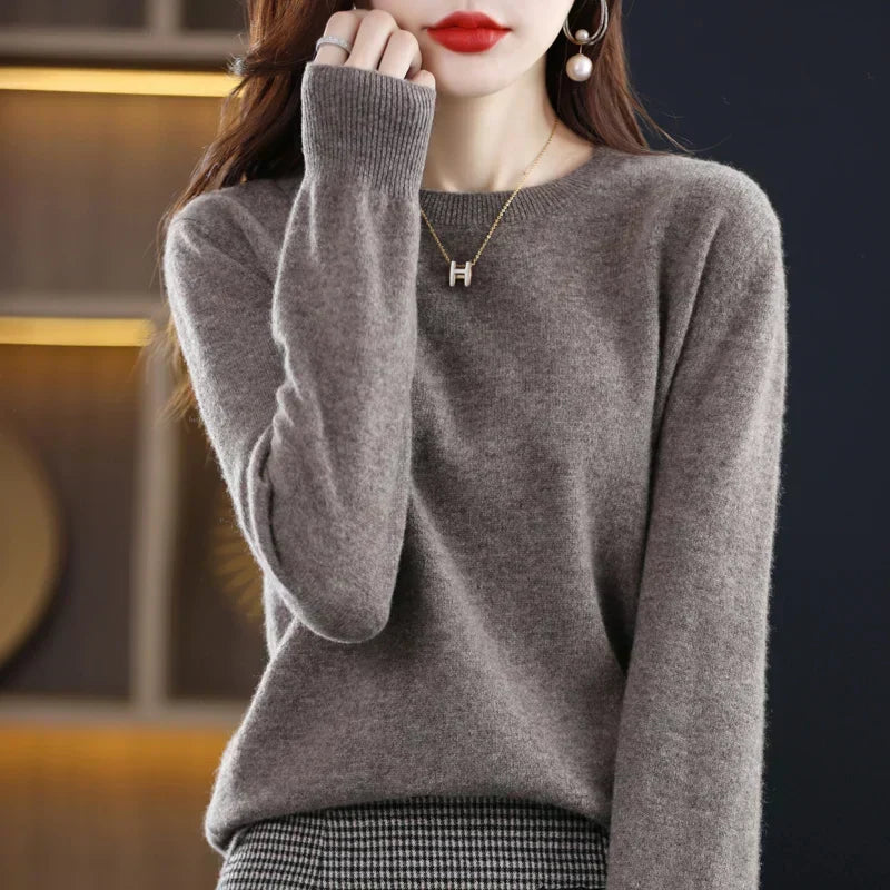 Model wearing the round-neck jumper in taupe-grey with a houndstooth skirt and gold pendant necklace 21