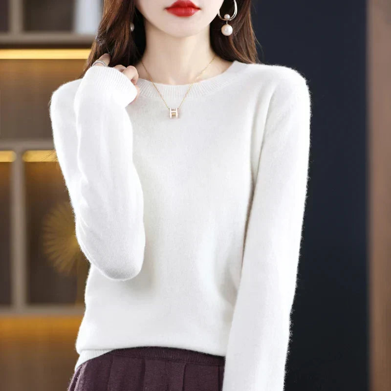 Model wearing the jumper in soft white with a burgundy skirt, hand touching her shoulder 7