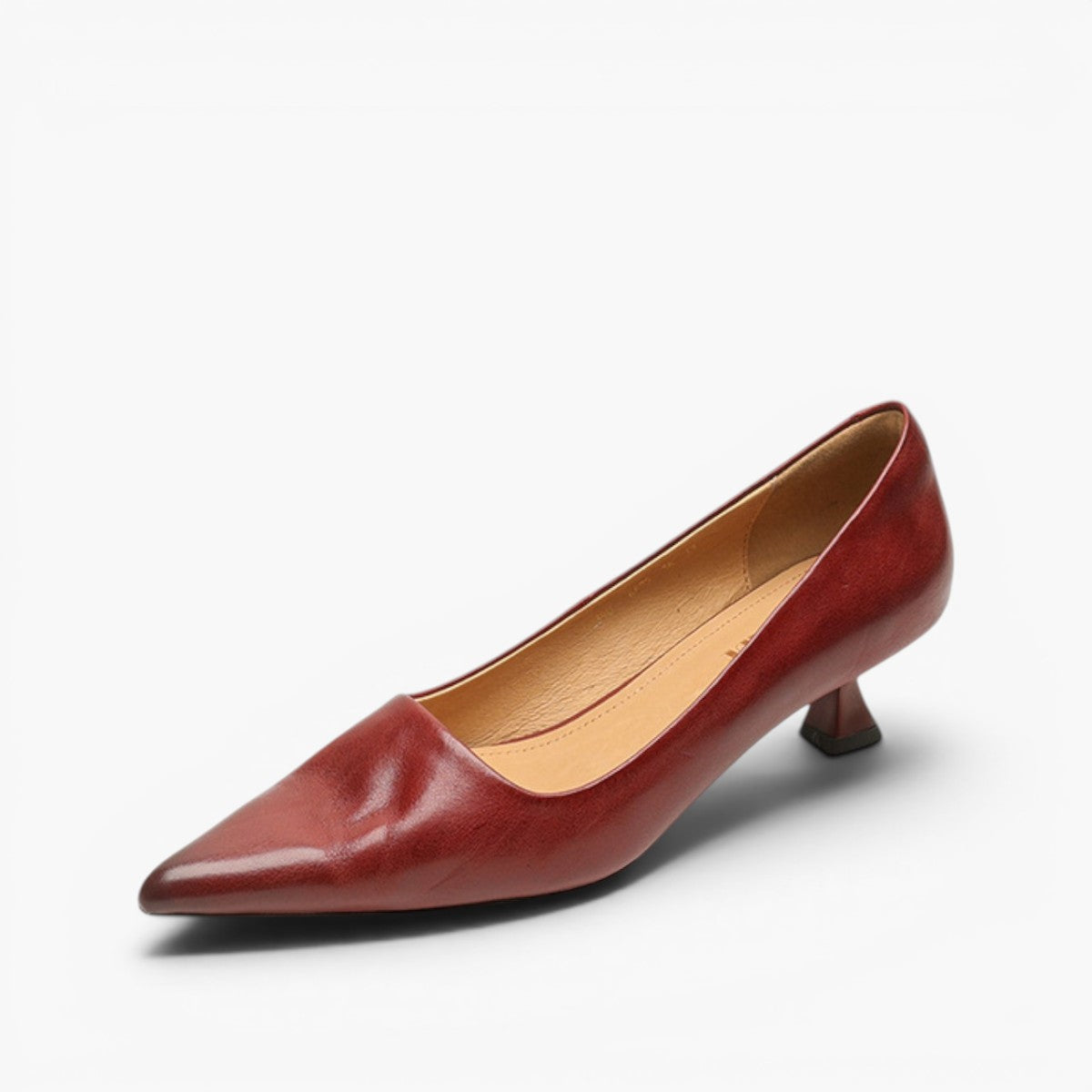 Single red leather pump on a white background, angled to show tan lining and kitten heel 7