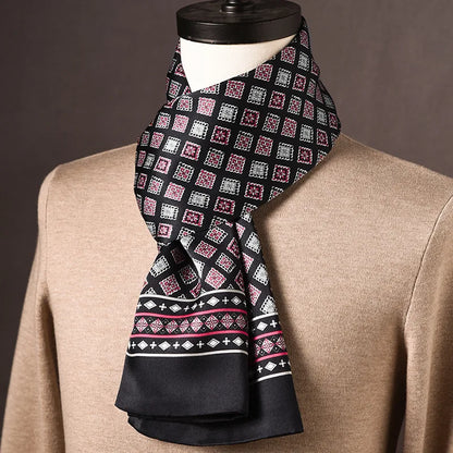 Black silk scarf with pink and white square motifs and a diamond-patterned border, with plain black ends, draped on a mannequin over a beige jumper. 15