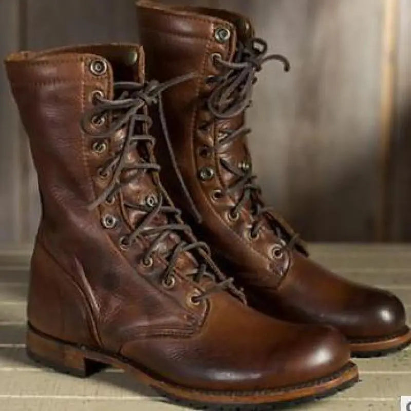 Pair of brown leather lace-up boots seen from the front and side, with fully laced eyelets and a chunky sole. 3