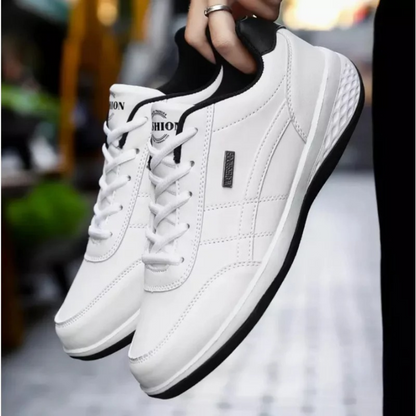 Pair of white lace-up sneakers with black heel lining and black sole edge, held up in one hand outdoors. 4