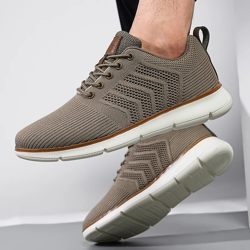 Taupe mesh trainer worn on a foot, with the other shoe raised to show its chunky white tread sole. 5