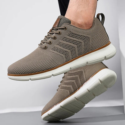Taupe mesh trainer worn on a foot, with the other shoe raised to show its chunky white tread sole. 5