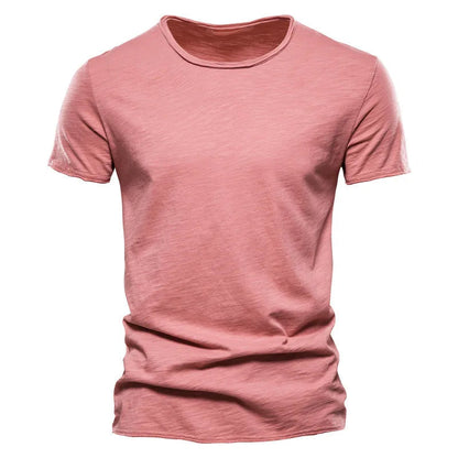 Front view of the short-sleeved crew-neck t-shirt in dusty coral pink, showing the textured slub fabric and raw-edged hems. 11