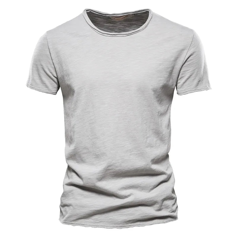 Front view of a short-sleeved crew-neck t-shirt in light grey with a subtle slub texture and raw-edged hems. 1