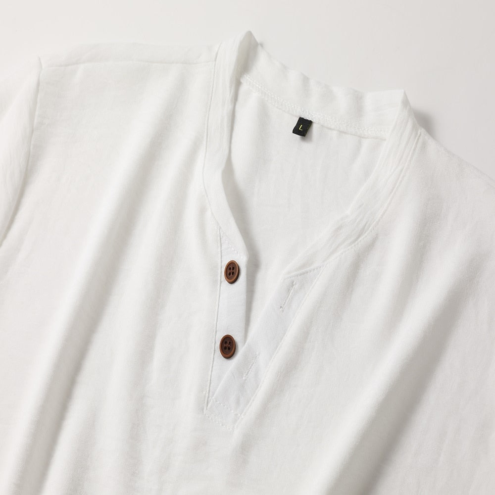 Close-up flat lay of the white top's V-neck collar, two brown four-hole buttons, stitched placket and small size label. 5