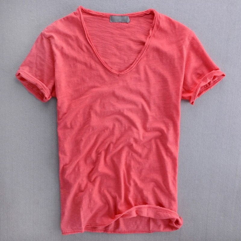 V-neck t-shirt in coral pink laid flat, showing the front view with rolled sleeve cuffs and a small label at the neck. 3