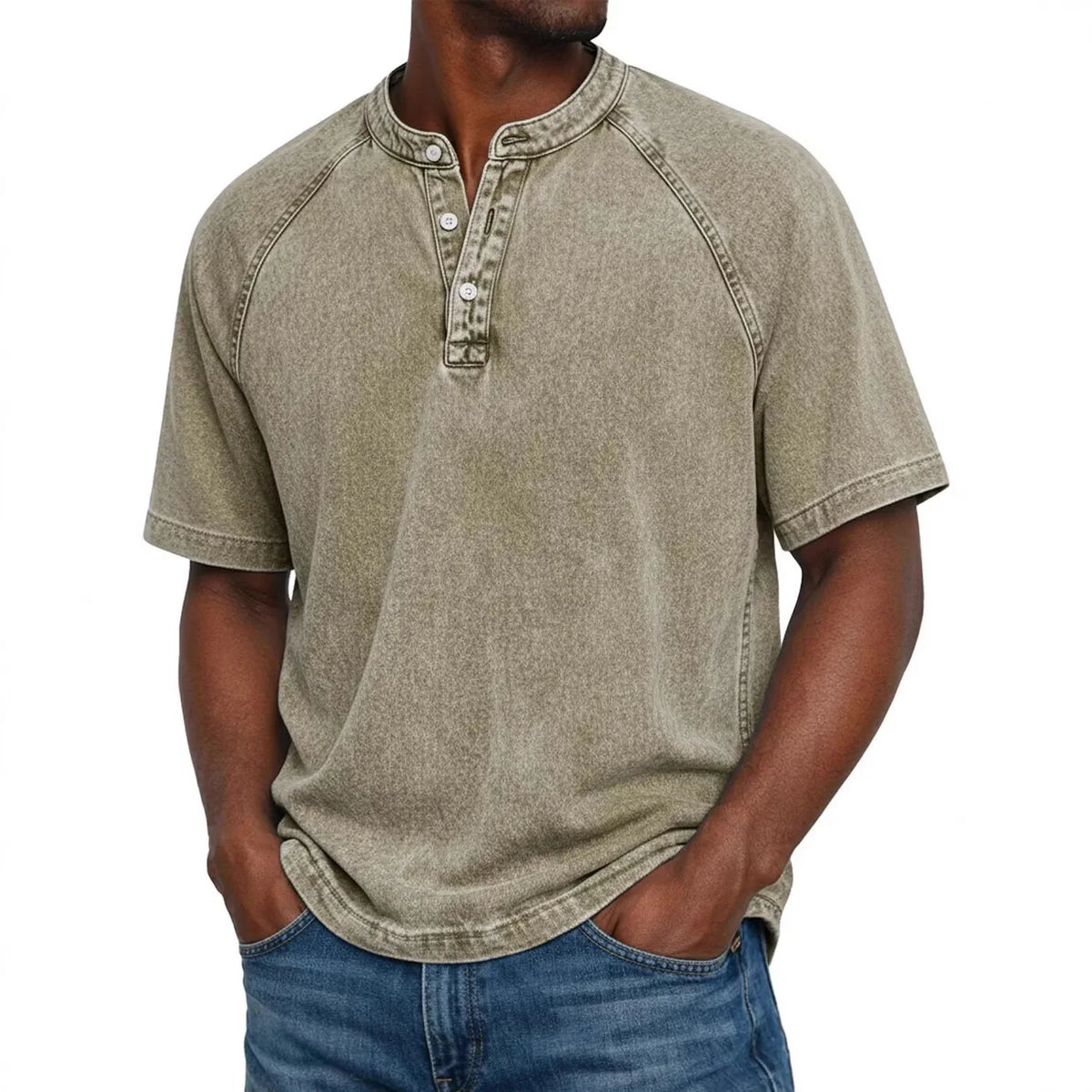 Man in a washed khaki-beige short-sleeve Henley with raglan sleeves and three-button placket, hands in jeans pockets. 9