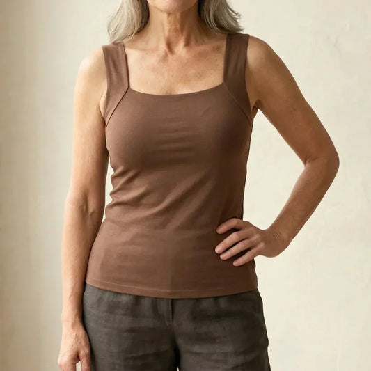 Front view of the brown square-neck tank worn with grey linen trousers, hand on hip 2