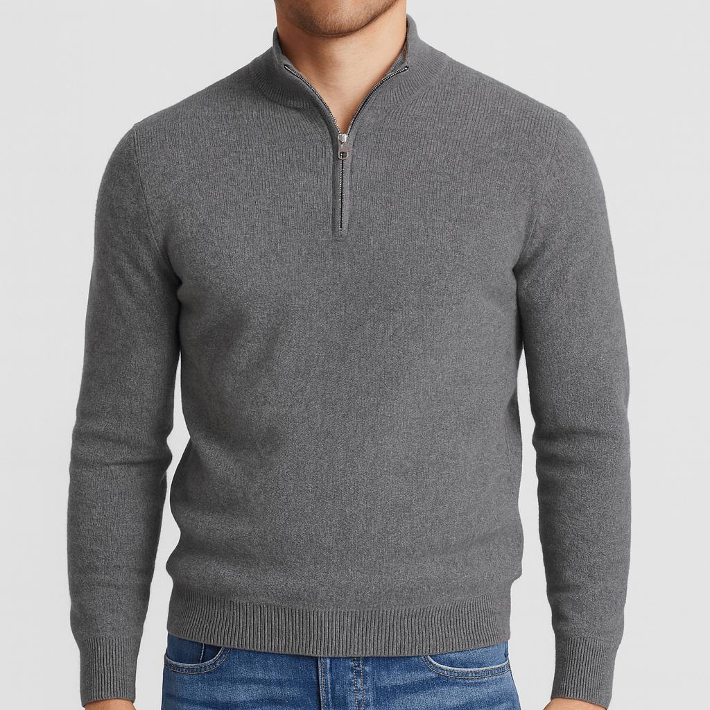 Man wearing a grey quarter-zip knit jumper with a silver zip and ribbed hem, paired with blue jeans. 4