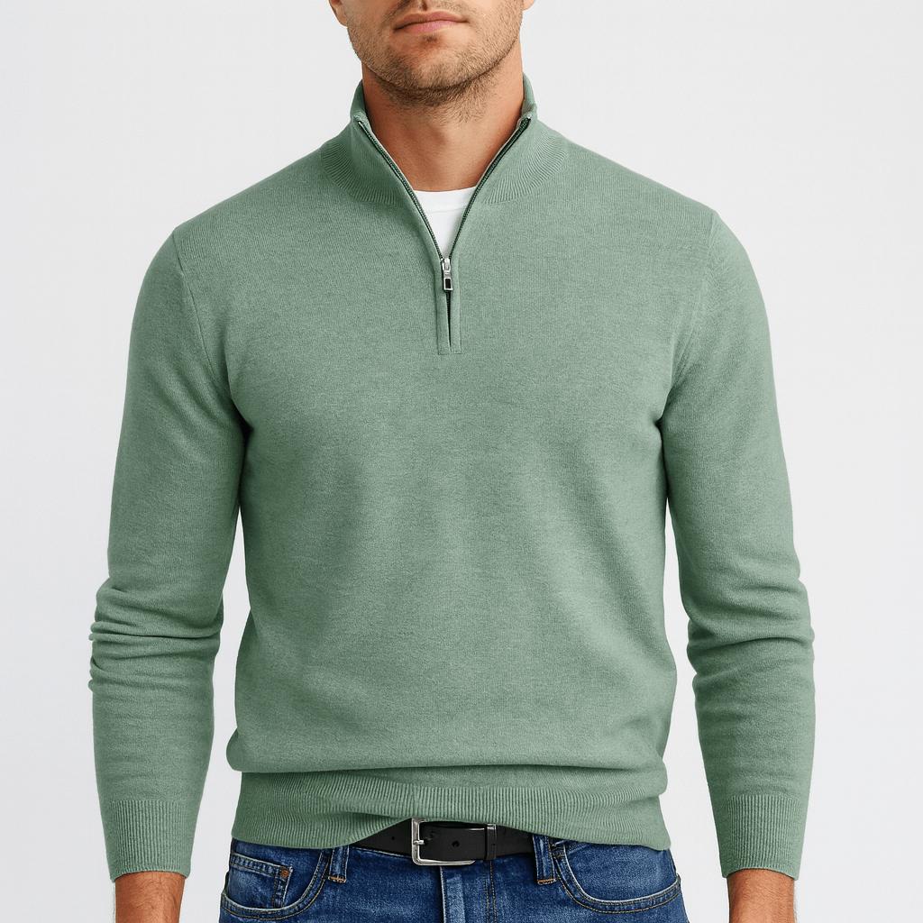 Man wearing a sage green quarter-zip knit jumper over a white tee, with blue jeans and a black belt. 12