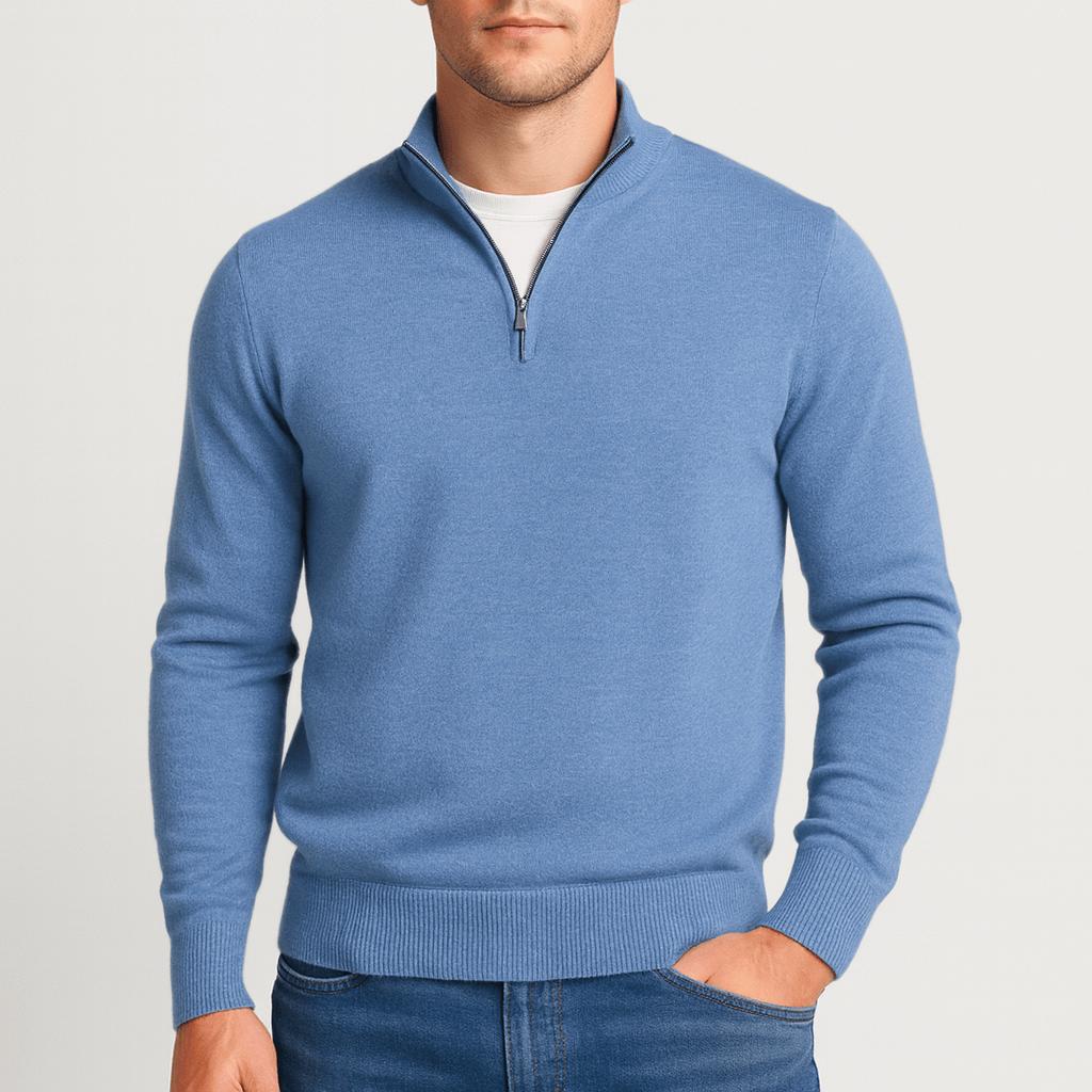 Man wearing a blue quarter-zip knit jumper, one hand in the pocket of his blue jeans, front view. 6