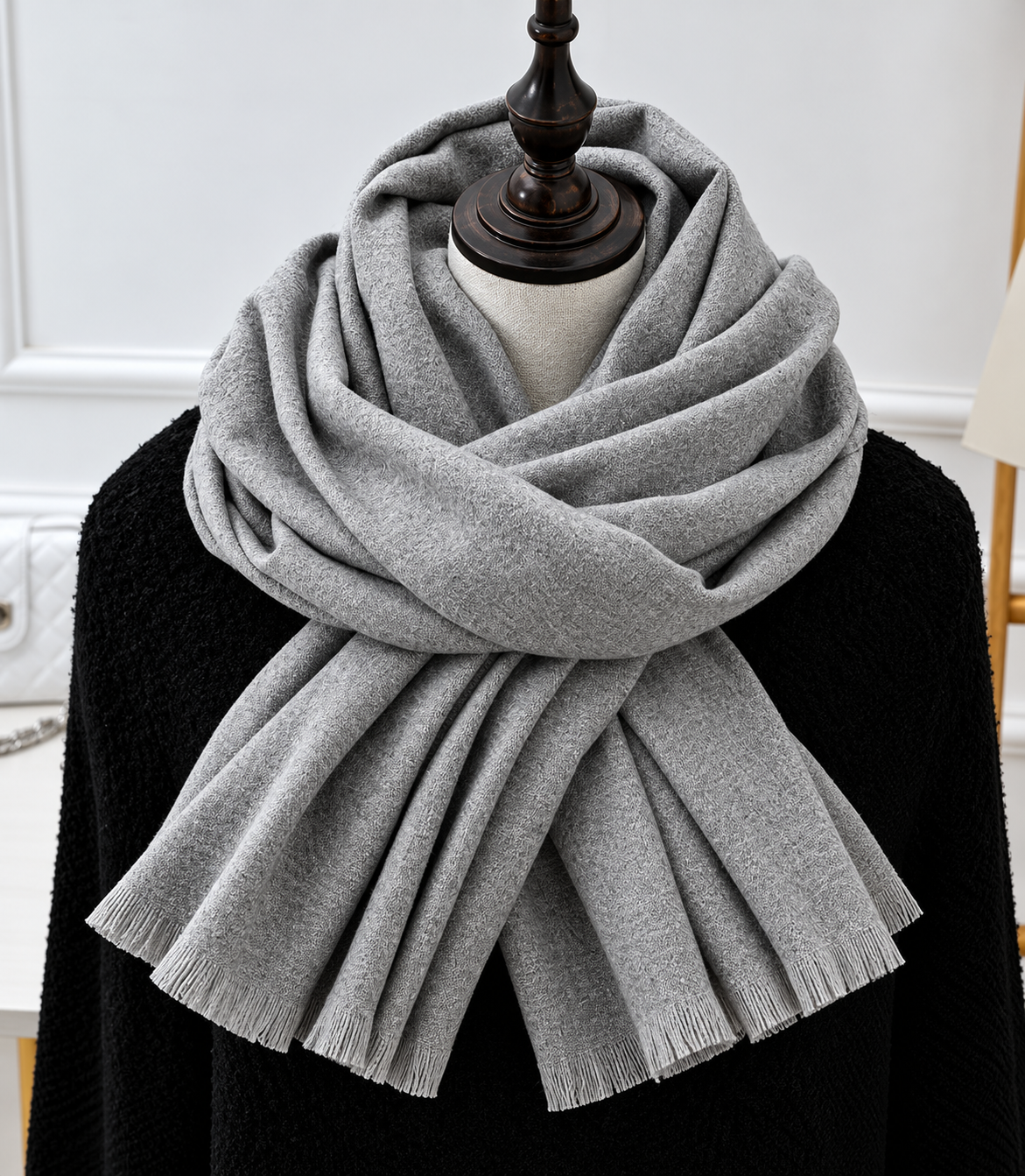 Light grey fringed scarf draped in soft folds around a mannequin in a black knit top 1