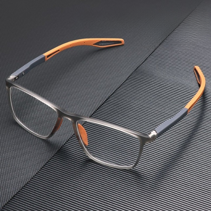 Translucent grey square glasses with orange arm tips and nose pads, resting on a dark textured surface. 3
