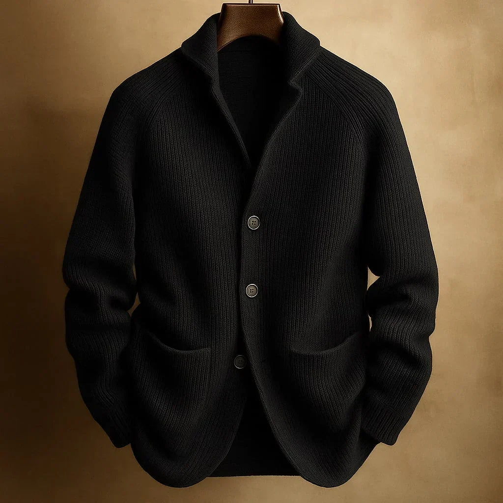 Black ribbed knit cardigan with three buttons, hanging on a wooden hanger against a tan backdrop 4