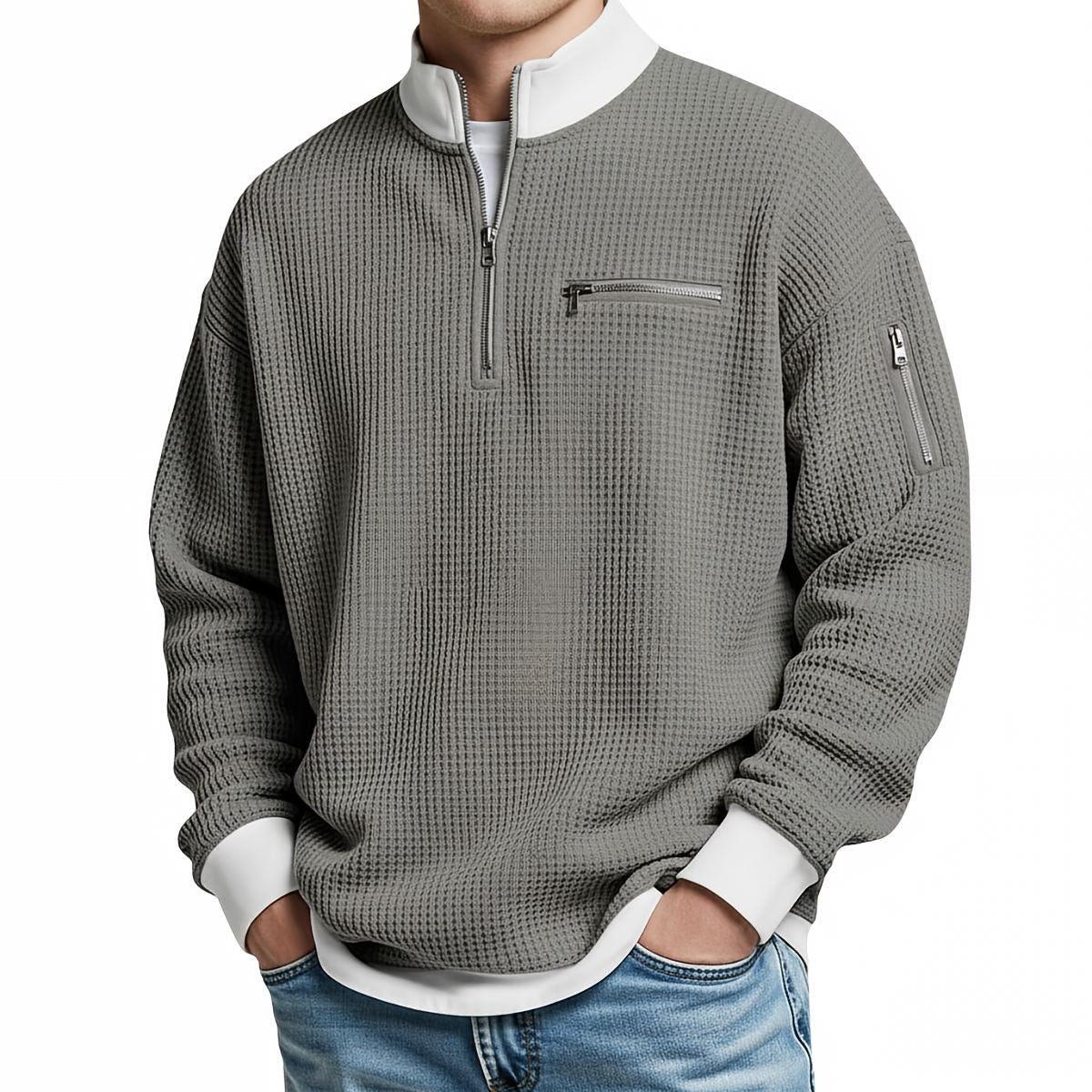 Front view of the mid-grey waffle-knit jumper on a model, with white collar and cuffs, quarter zip and zipped chest pocket. 8