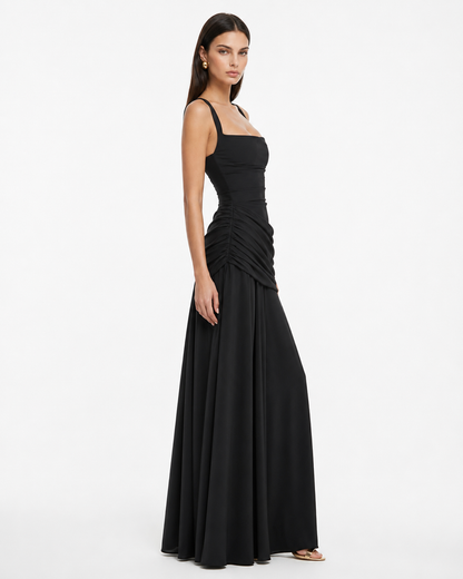 Side view of the black maxi dress, showing ruched gathers at the hip and a flowing floor-length skirt. 13