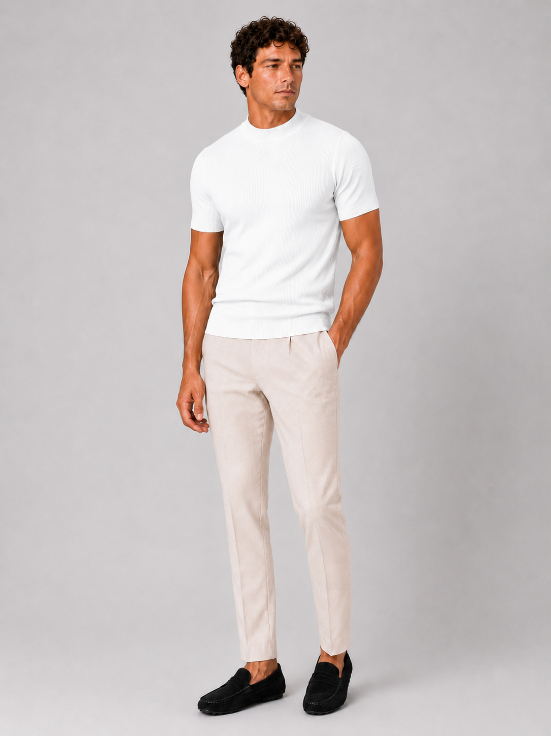 Full-length studio shot of the white ribbed top worn with cream trousers and black suede loafers. 13