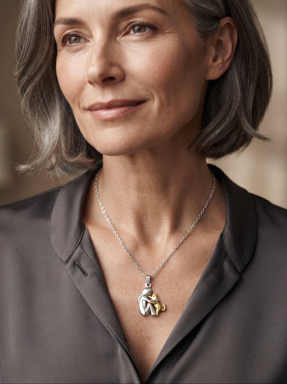 Woman with grey bobbed hair wearing the pendant with a gold-toned cat, in a grey collared blouse 10