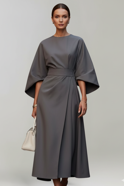 Model wearing the dress in charcoal grey, with a cream handbag 10