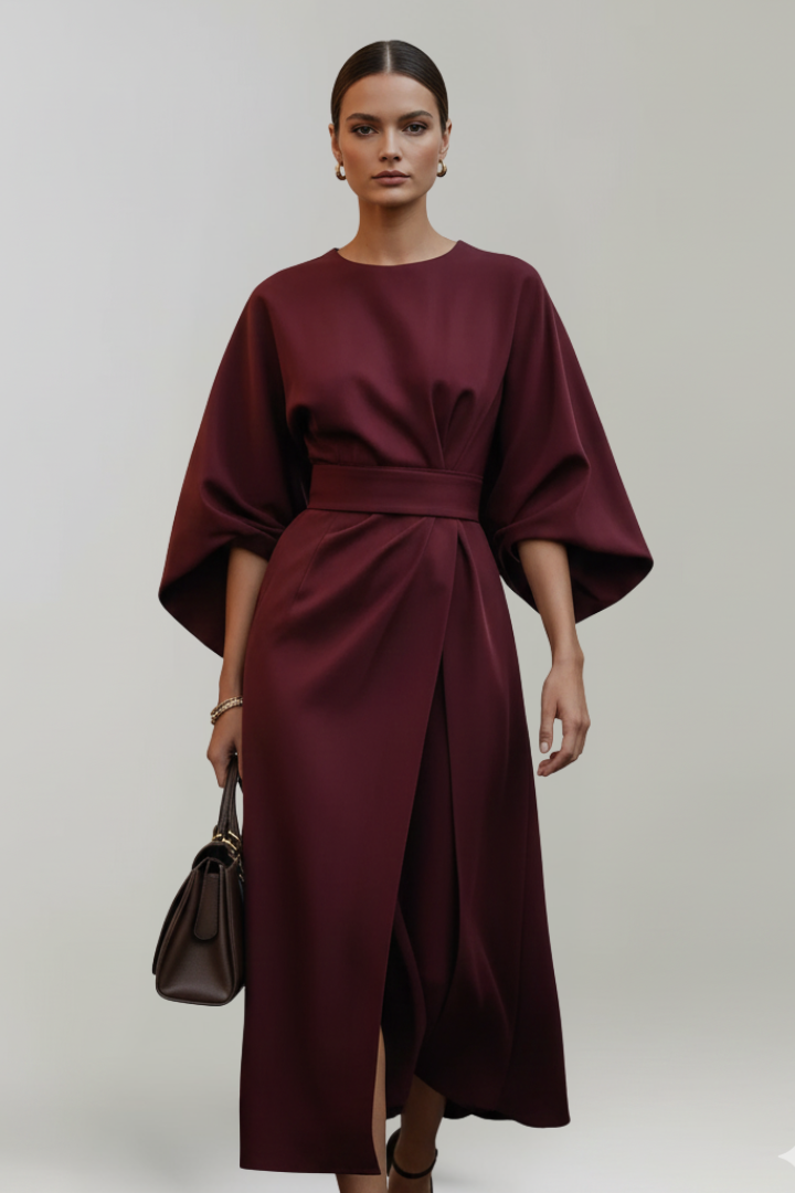 Model wearing the dress in burgundy, front view, holding a dark brown handbag 11