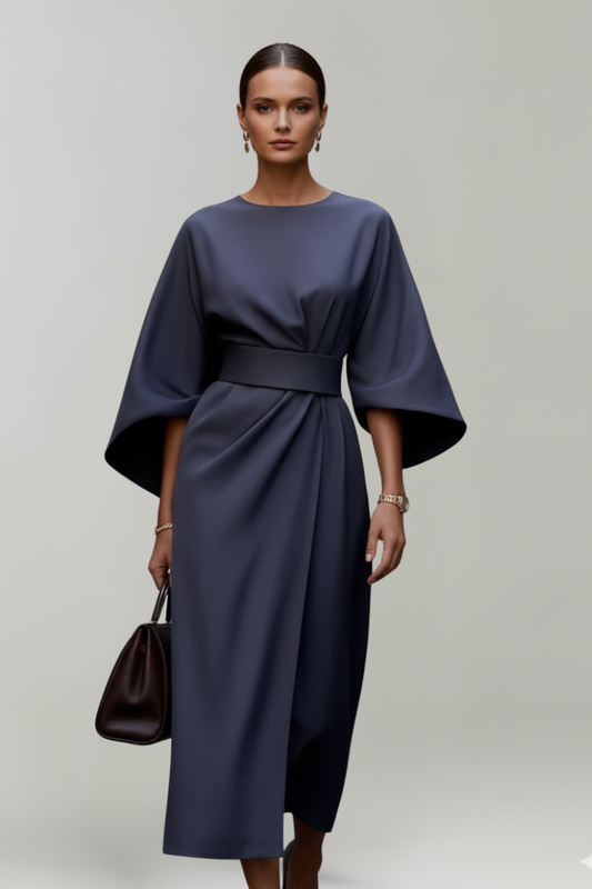Model wearing the navy dress, front view, holding a dark brown handbag 2