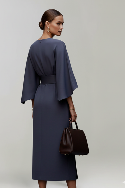Back view of the navy dress on a model, showing the rear zip and wide sleeves 4