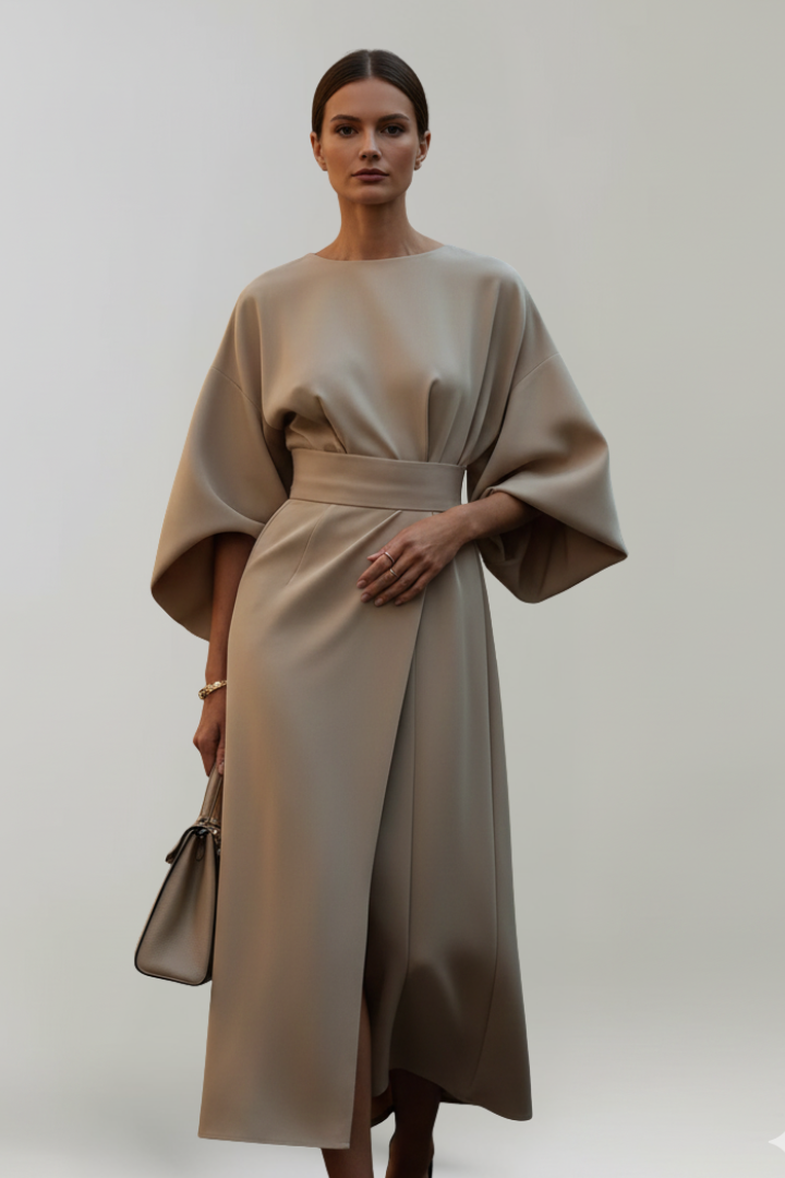 Model wearing the dress in a taupe beige shade, with a matching handbag 6