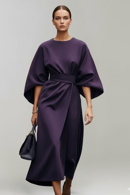 Model wearing the dress in deep purple, carrying a dark navy handbag 9