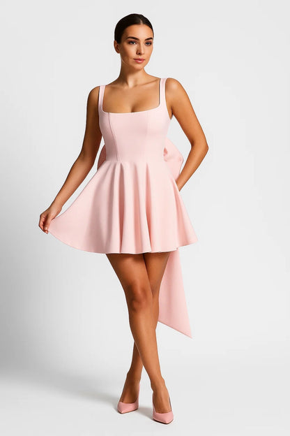 Model wearing the dress in pale pink with matching heels, lifting the flared skirt 6