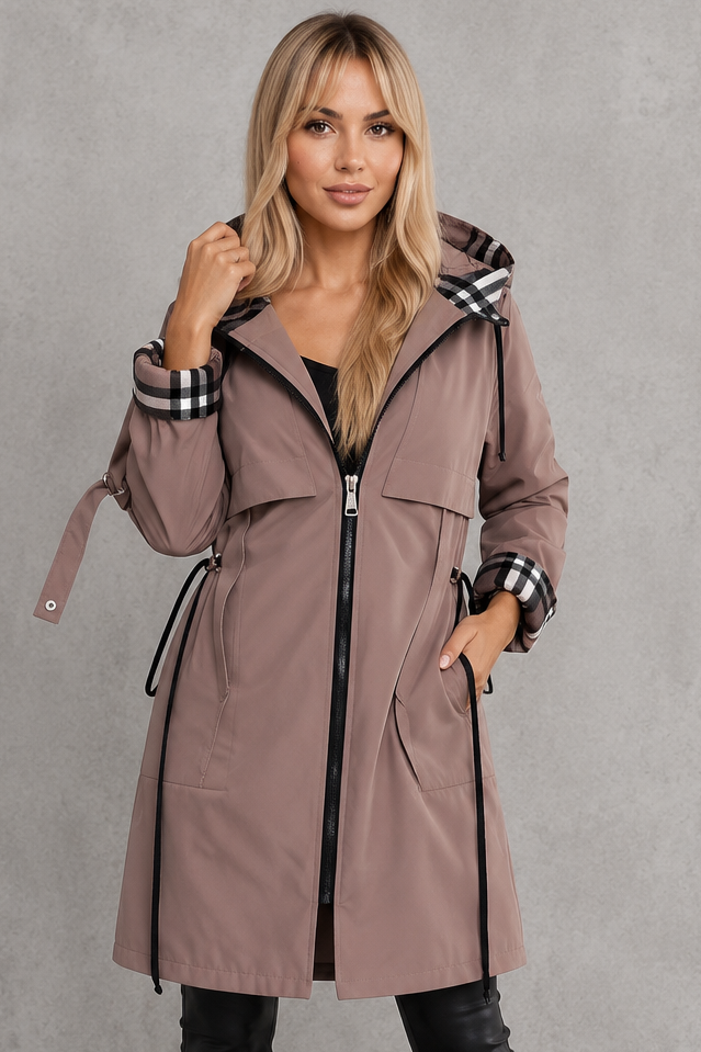 Close-up of a model in the mauve hooded rain coat, zipped, showing chest flaps, drawcord waist and checked cuff lining. 1