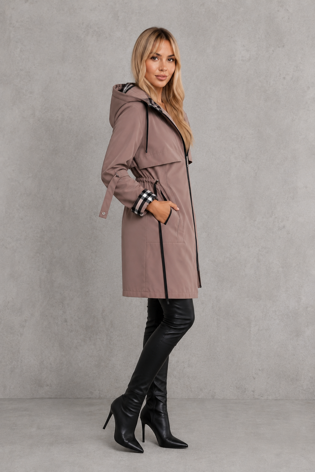 Side view of the mauve hooded coat on a model, with hand in pocket, belted sleeve tab and drawcord waist. 4