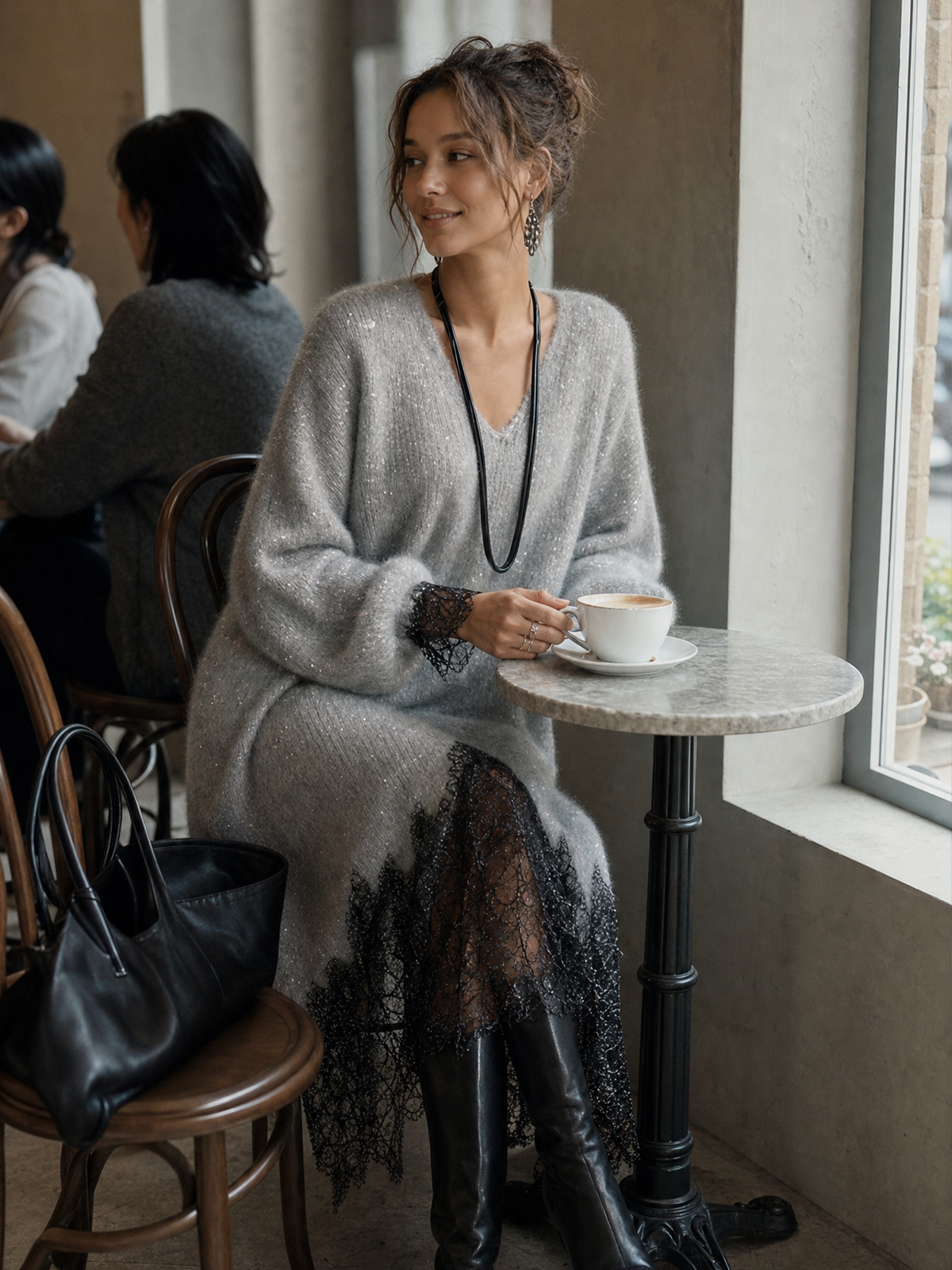 Model seated at a small marble café table in the grey dress, holding a coffee cup 4