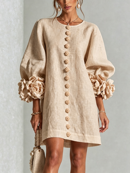 Close front view of the beige linen dress, with a line of knotted flower buttons and rose cuffs on puffed sleeves. 23