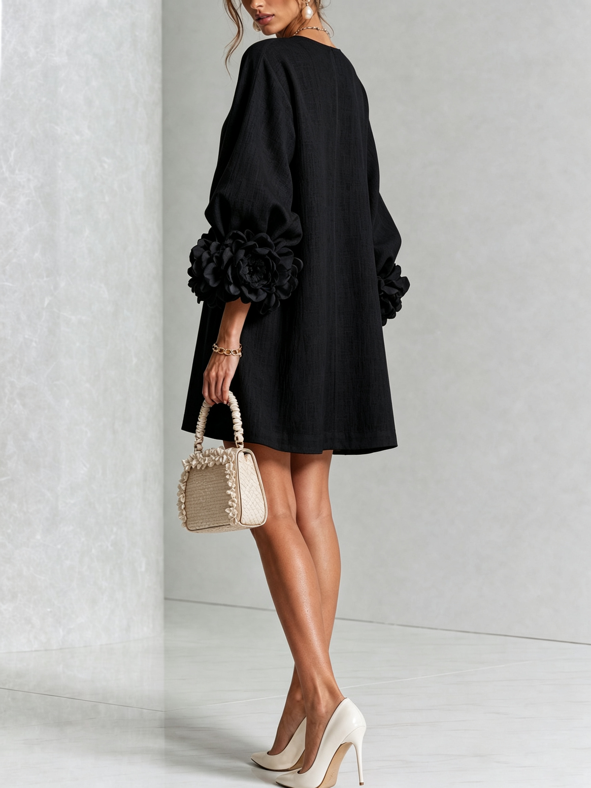 Back view of the black dress, showing rose cuffs and a straight, relaxed shape 17