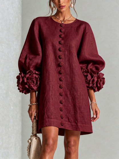 Close front view of the deep burgundy dress, showing the line of flower buttons and large flower cuffs. 35